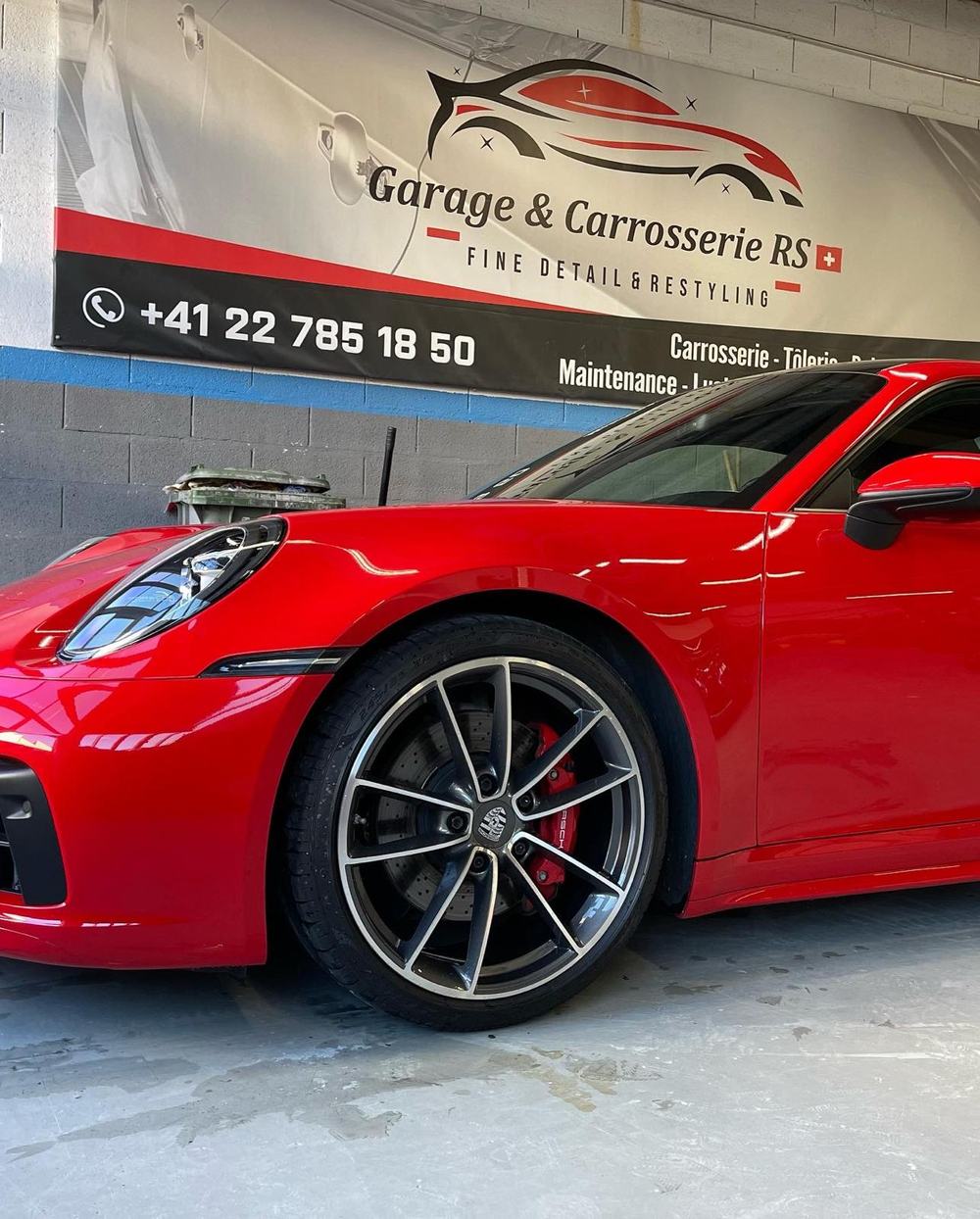 Roue et aile avant d'une Porsche 911 rouge dans l'atelier